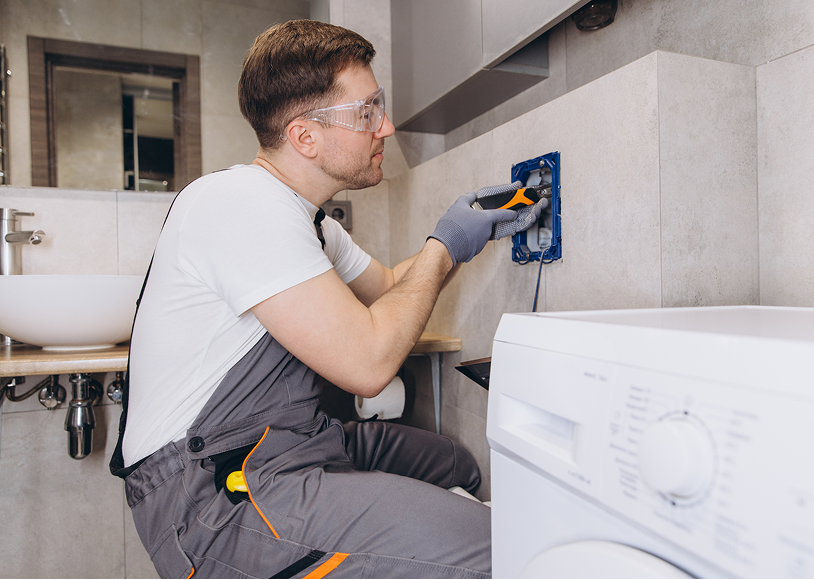 Technician installing electrical outlet in bathroom