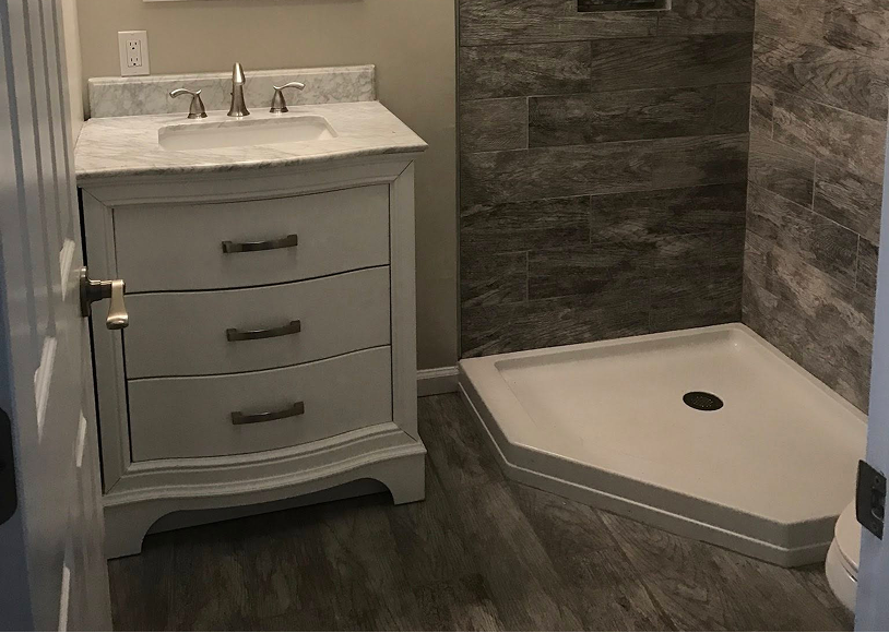 Bathroom with sink and corner shower area.