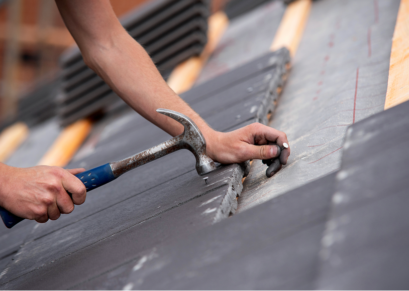 Hands working on roof construction