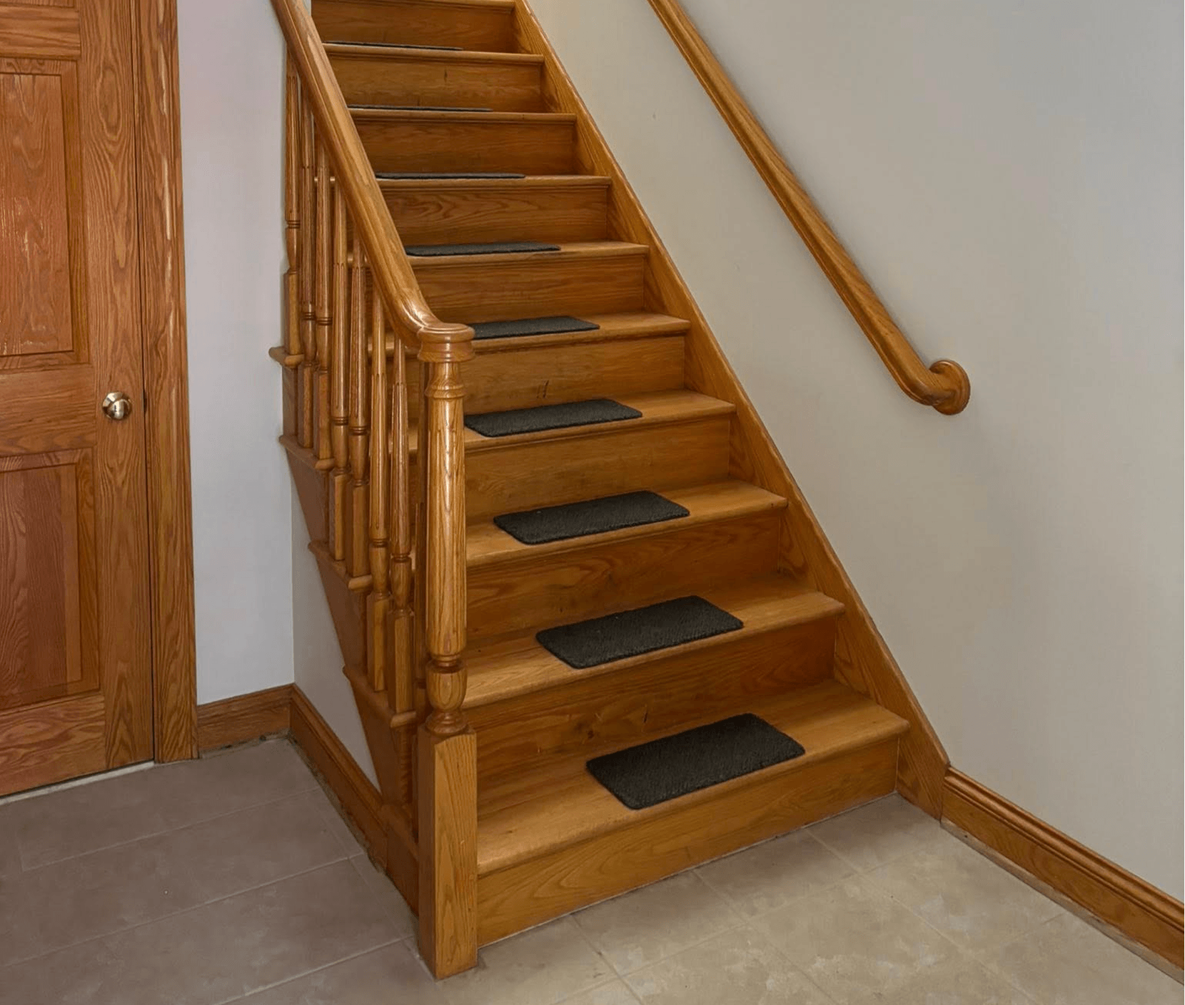 Wooden staircase with handrail and step mats